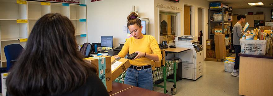 An SPU student worker scans a package